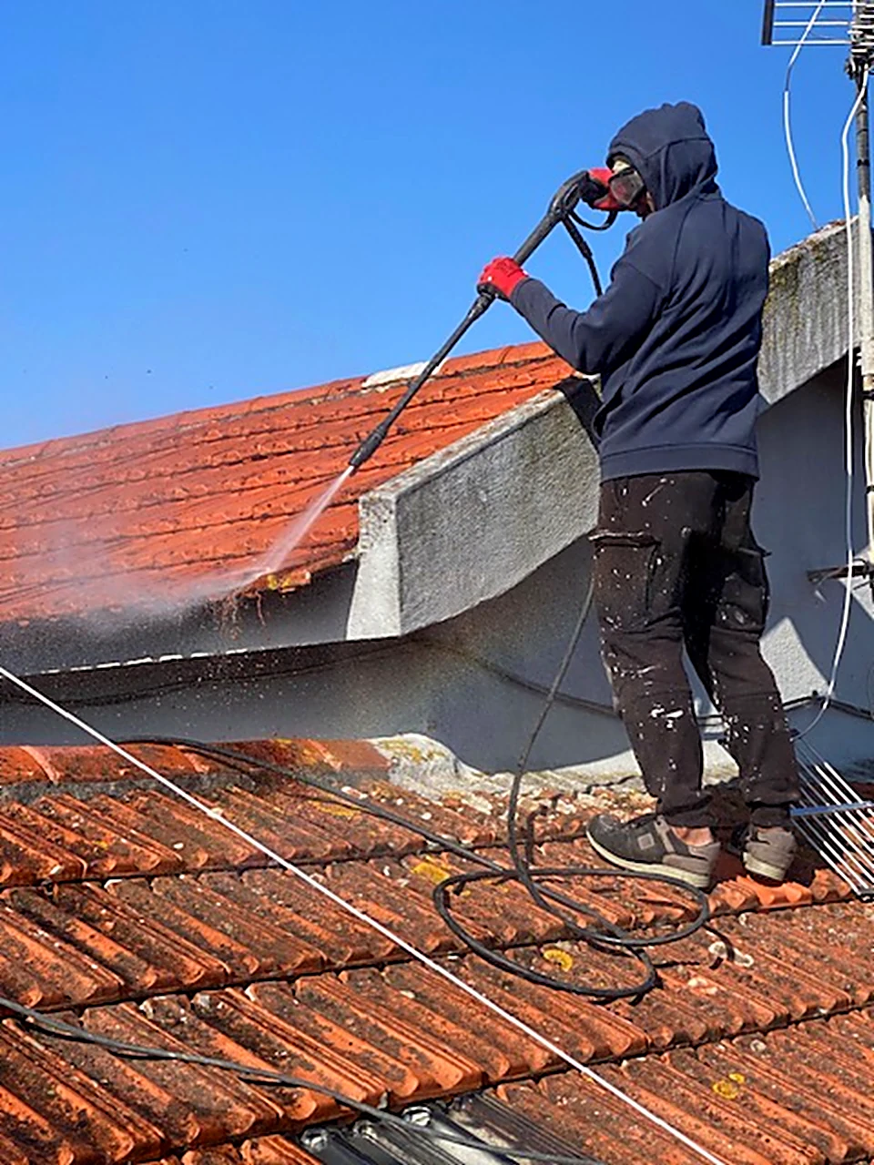 Técnico da Consiva a lavar a alta pressão uma cobertura em telha cerâmica